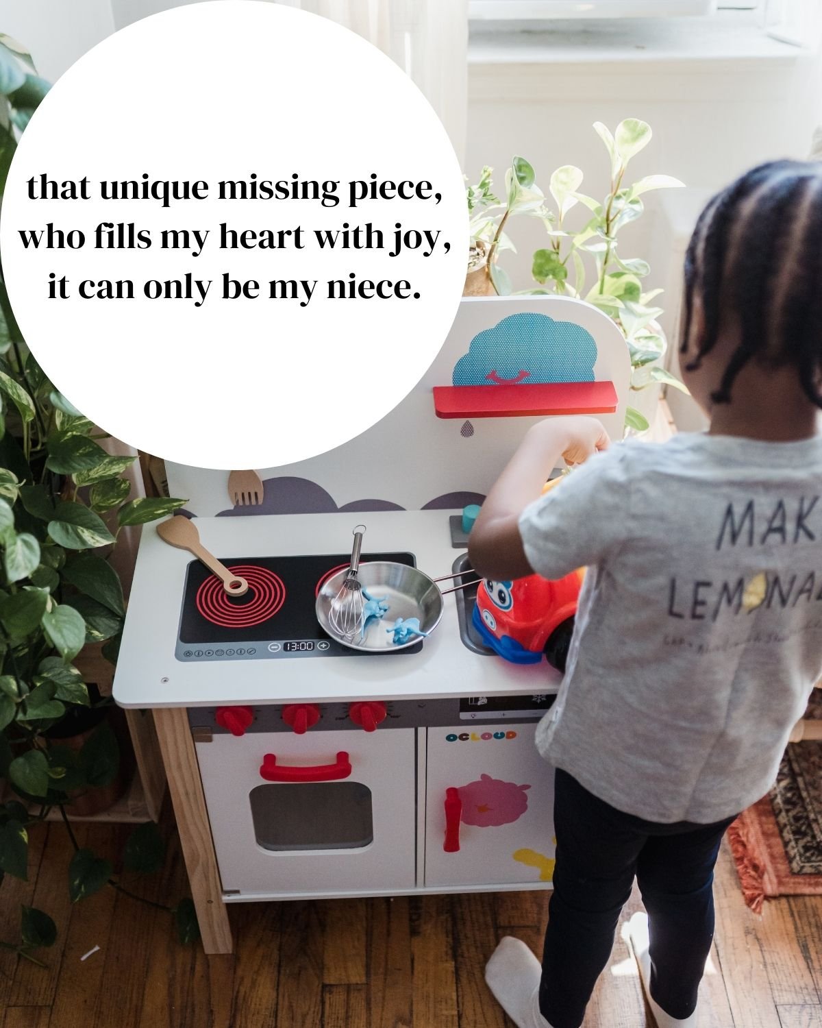 A kid playing with a toy kitchen