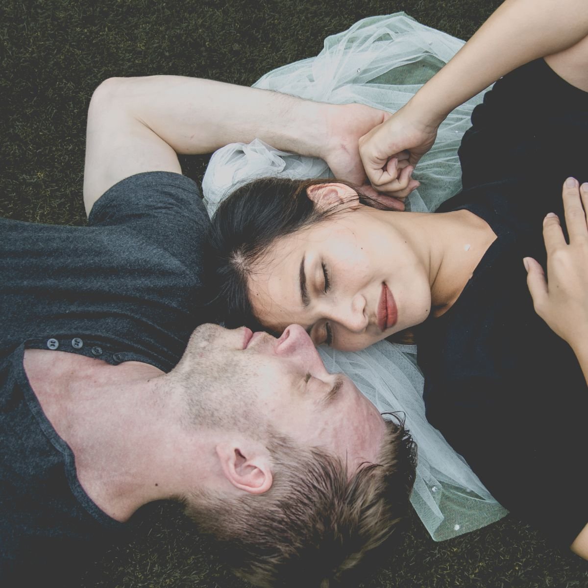 A couple laying in the grass